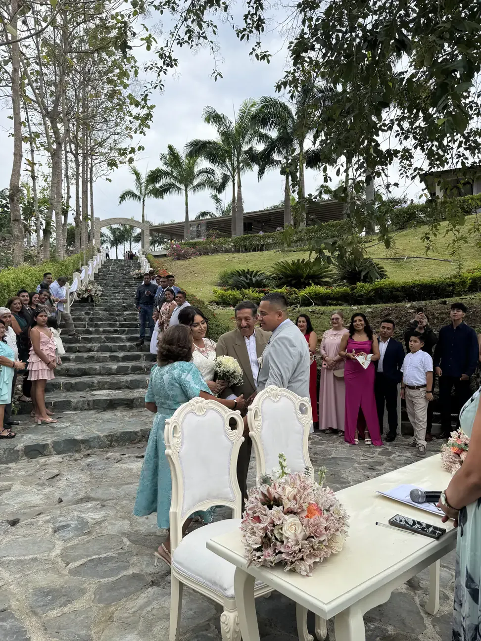 Novios saludando a dos invitados en la mesa de ceremonia junto a la escalinata de Casa Grande Resort