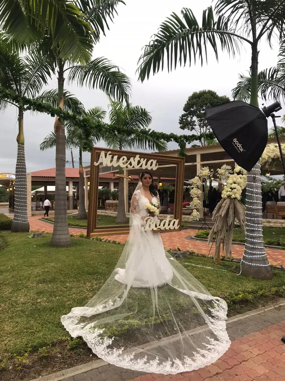 Novia con velo largo posando en los jardines de Casa Grande Resort