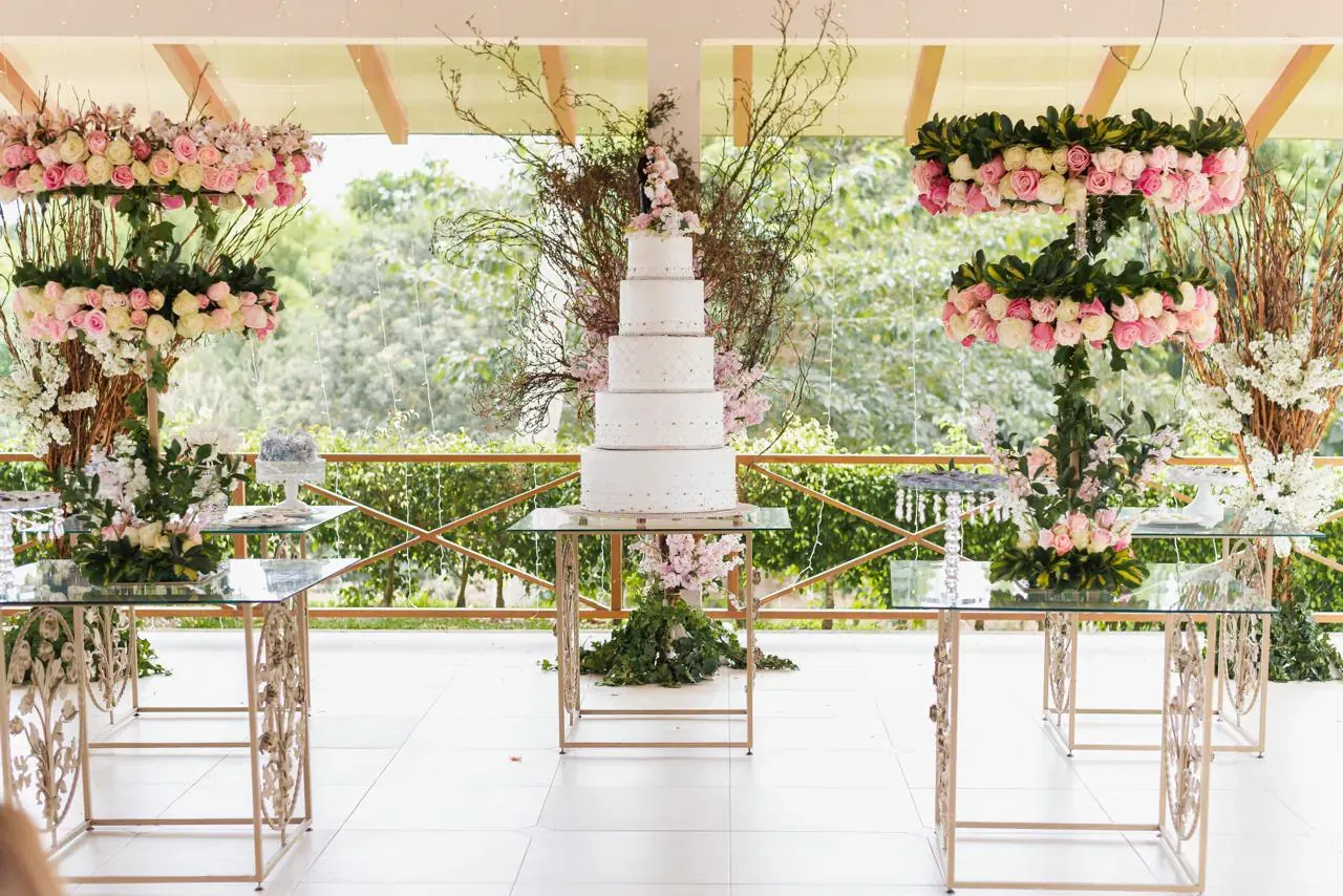 Pastel de bodas de varios pisos con arreglos de flores en Casa Grande Resort