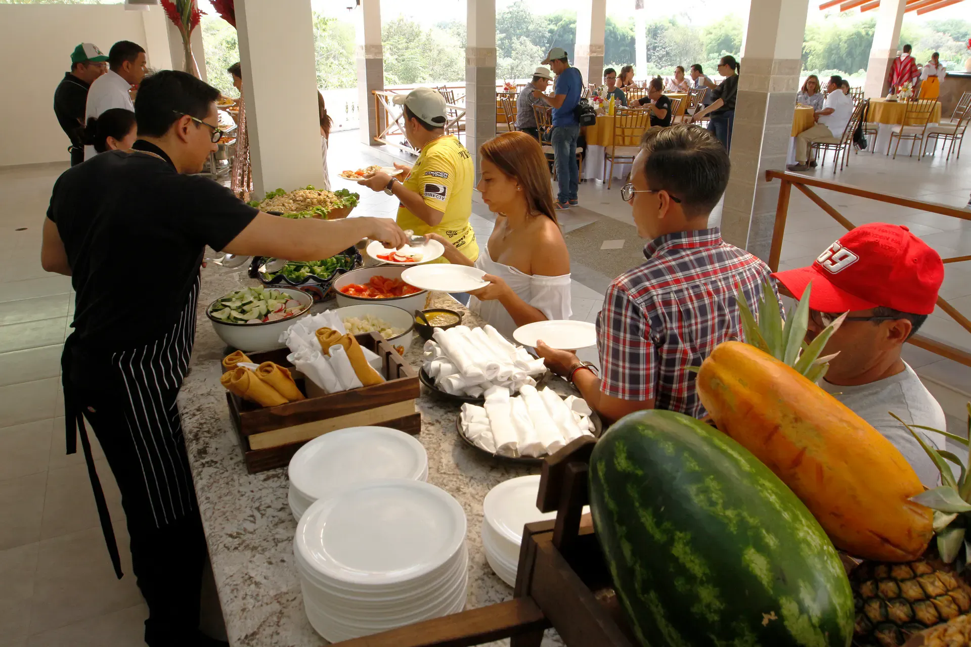 Cocinero sirviendo el buffet con frutas y platos frescos en Casa Grande Resort