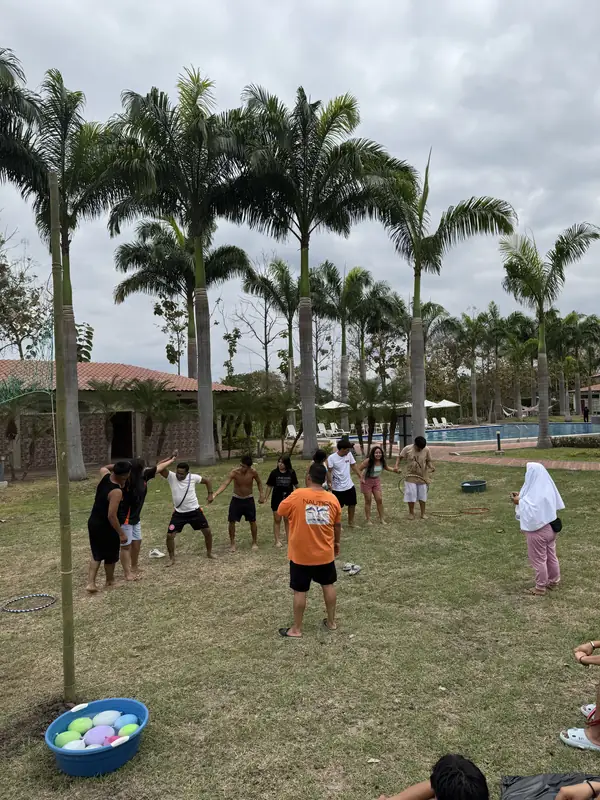 Grupo participando en juegos sobre el césped entre palmeras de Casa Grande Resort