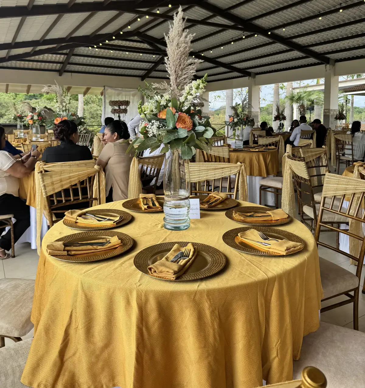 Mesa con mantel dorado y centro floral preparada para un evento en Casa Grande Resort