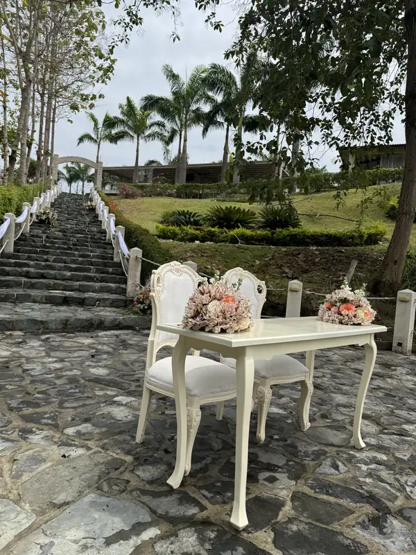 Mesa y sillas blancas para una ceremonia junto a la escalinata de Casa Grande Resort