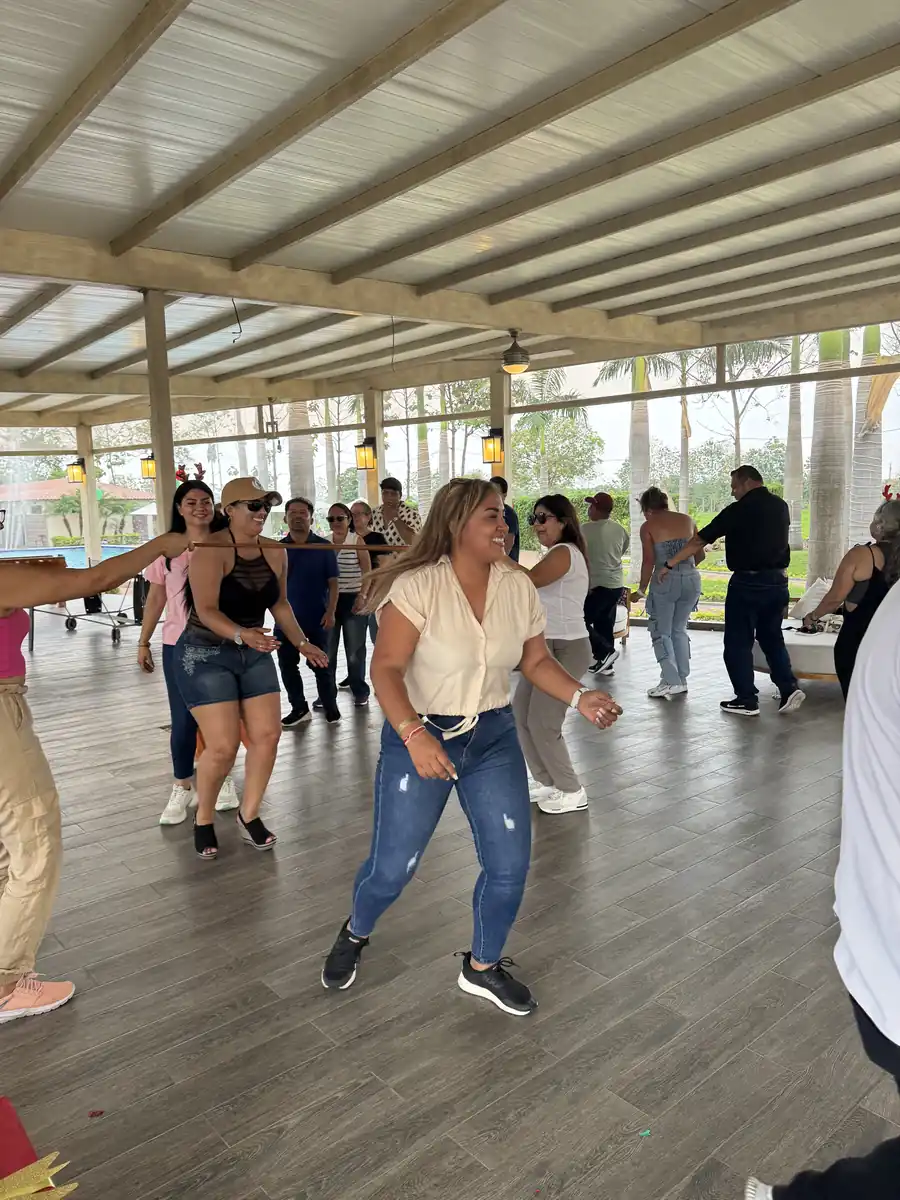 Invitados bailando en fila durante una celebración en la terraza techada de Casa Grande Resort