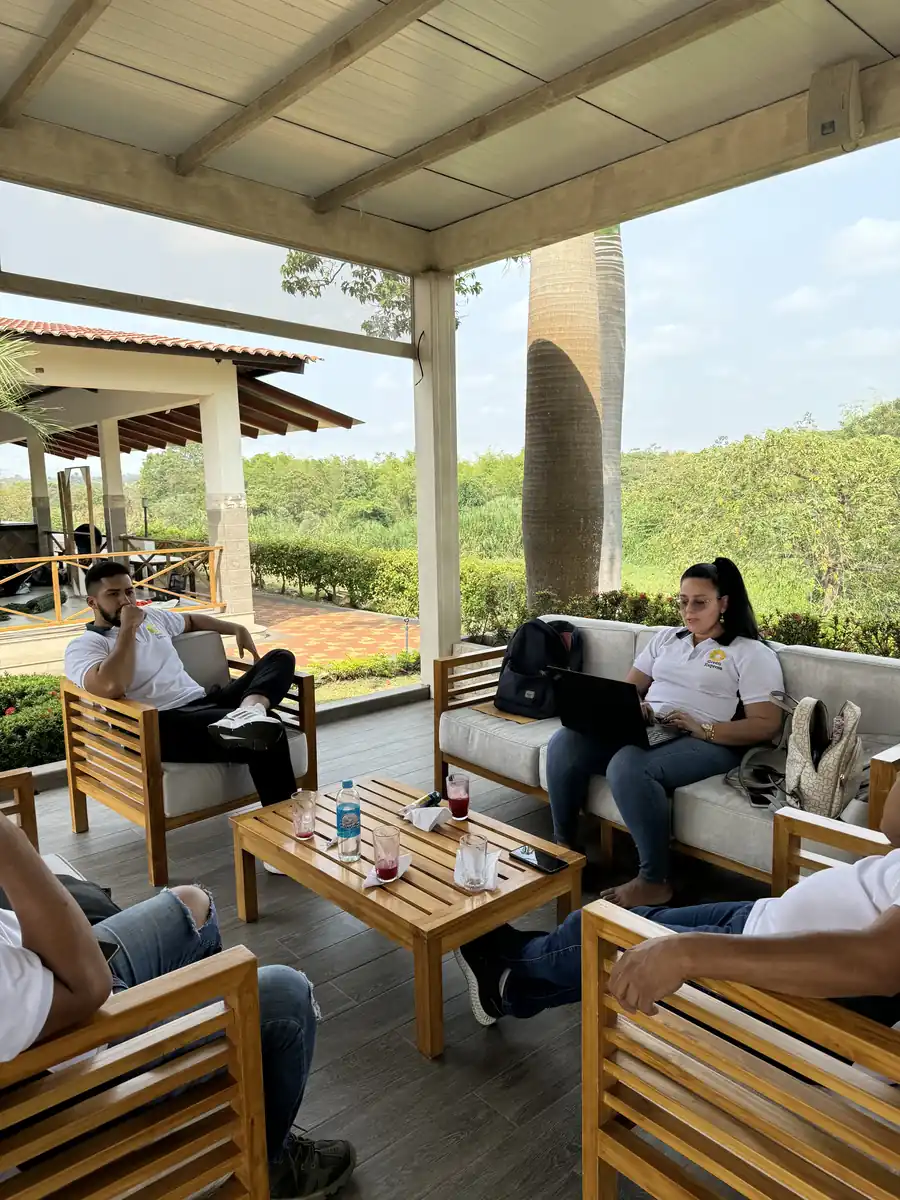 Grupo reunido en una terraza techada con muebles de madera en Casa Grande Resort