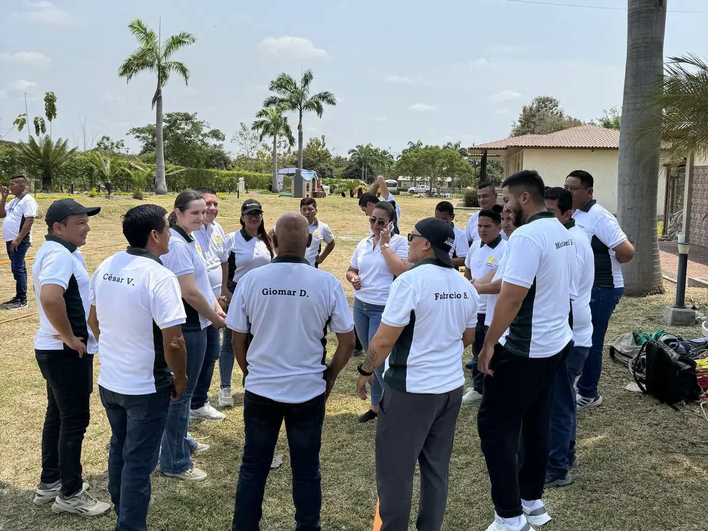 Equipo de trabajo reunido en círculo en las áreas verdes de Casa Grande Resort