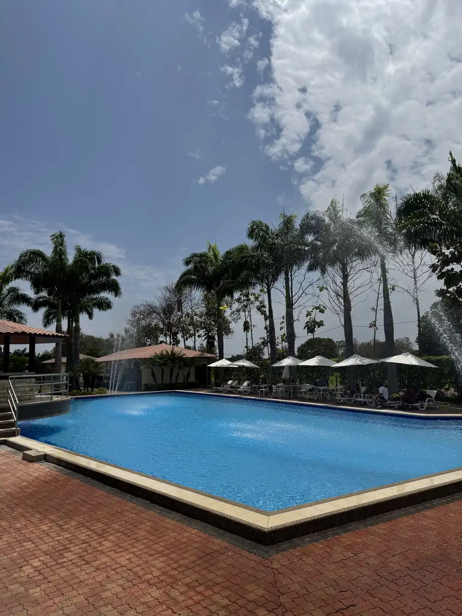 Piscina con fuentes de agua rodeada de palmeras en Casa Grande Resort