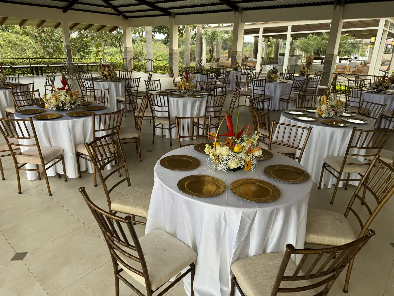 Salón de eventos con mesas redondas y sillas doradas en Casa Grande Resort